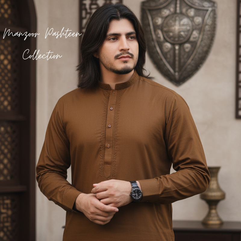 Male model in light grey cotton kurta shalwar posing against pastel blue and beige wall — Abid Jee men’s traditional fashion summer collection.